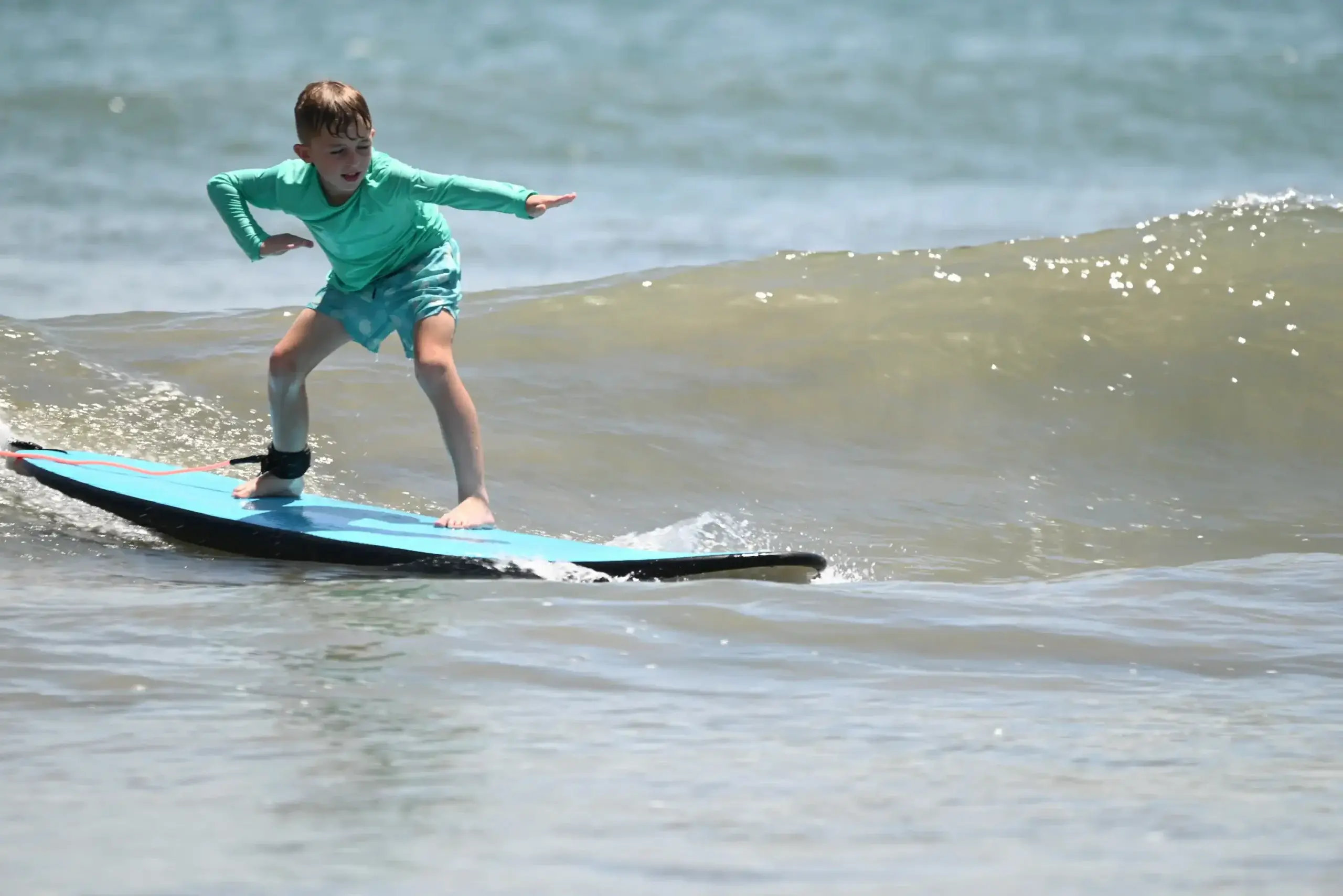 Certified bilingual surf instructor teaching a child on the beach at Cocoa Beach