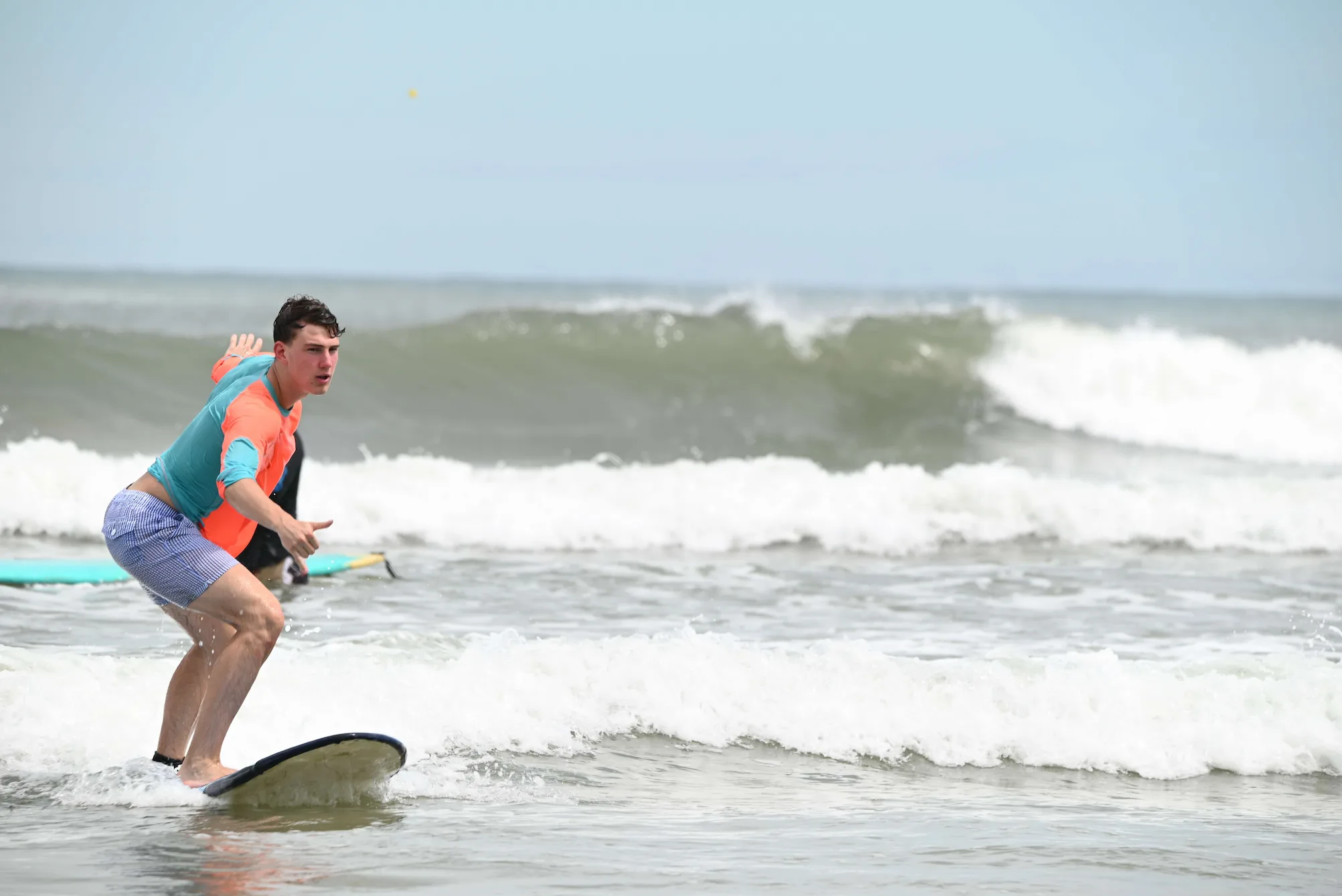 Certified Cocoa Beach surf coach reviewing technique with an intermediate surfer in the lineup