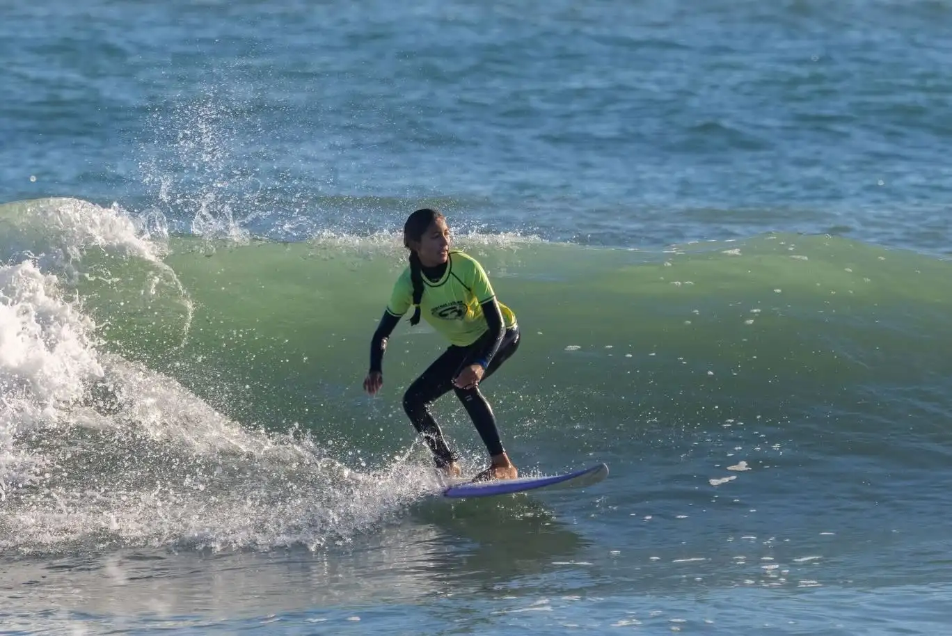 Surf instructor guiding student on a wave at Cocoa Beach